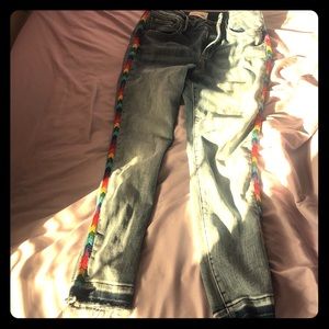 Retro jeans with rainbow stitching on the sides.